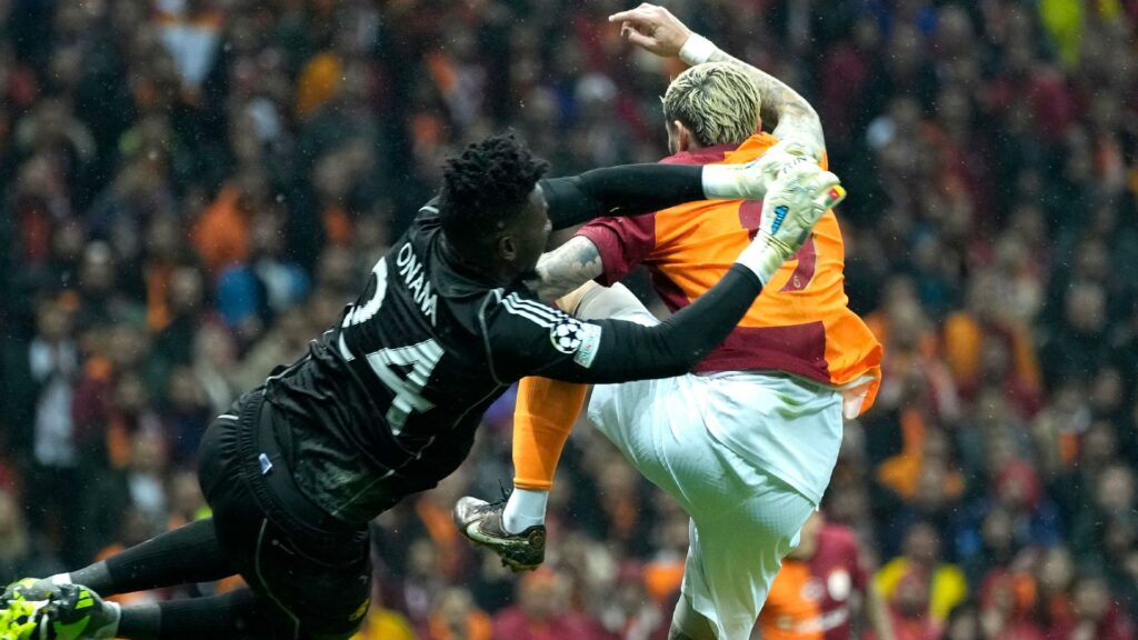 Andre Onana, left, punches the ball away under pressure from Galatasaray’s Mauro Icardi (Francisco Seco/AP)